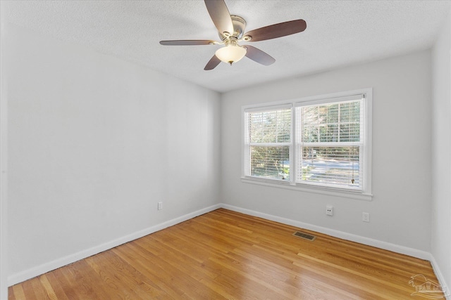 empty room featuring ceiling fan, light hardwood / wood-style flooring, and a textured ceiling