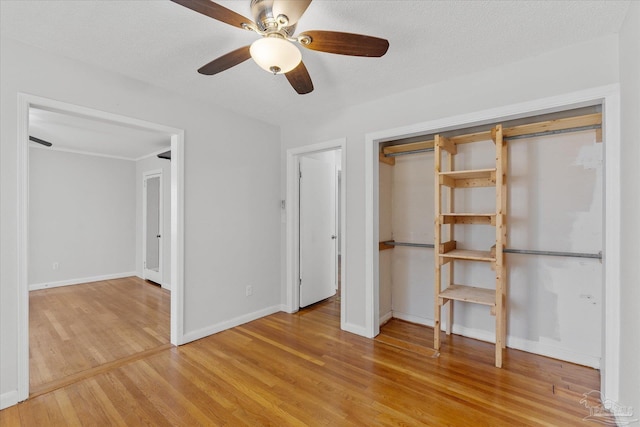 unfurnished bedroom featuring a textured ceiling, light hardwood / wood-style floors, a closet, and ceiling fan