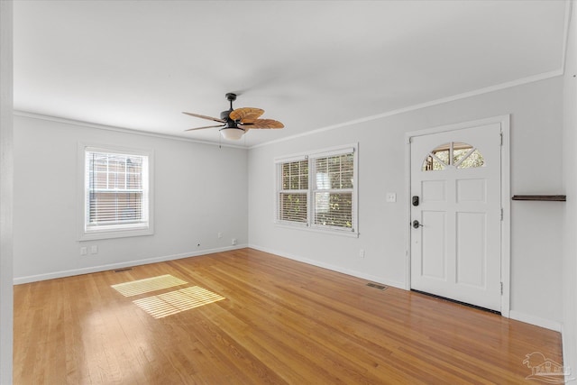 foyer entrance with crown molding and a wealth of natural light