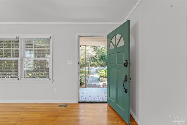 entrance foyer featuring crown molding and light hardwood / wood-style flooring