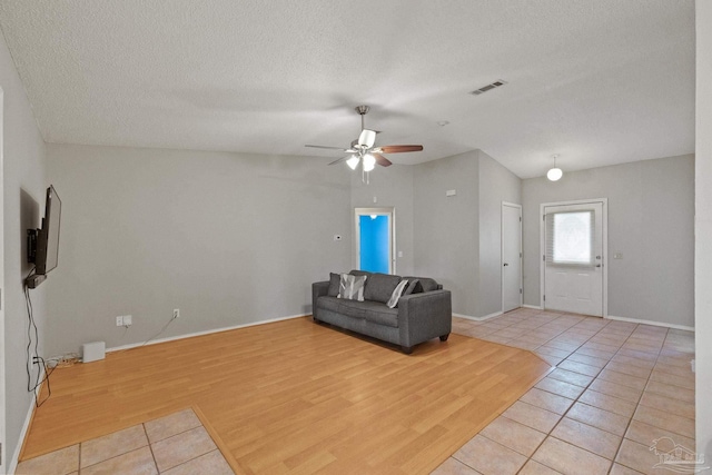 unfurnished living room with ceiling fan, light hardwood / wood-style flooring, and a textured ceiling