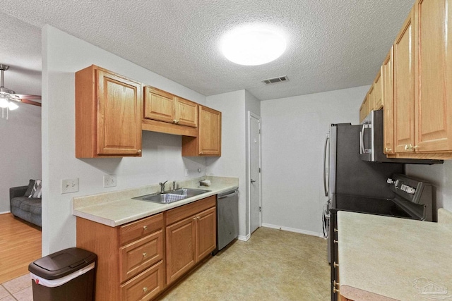 kitchen featuring ceiling fan, sink, a textured ceiling, and appliances with stainless steel finishes