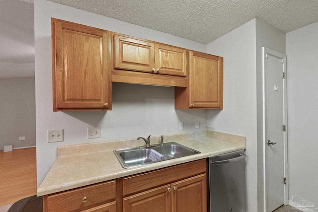 kitchen with dishwasher, hardwood / wood-style floors, a textured ceiling, and sink