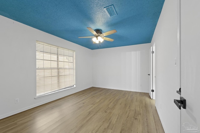 unfurnished room featuring a textured ceiling, light hardwood / wood-style flooring, and ceiling fan