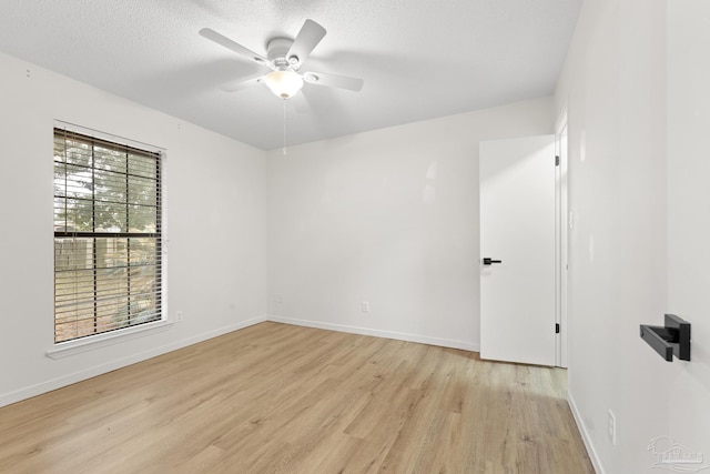 spare room with ceiling fan, a textured ceiling, and light hardwood / wood-style floors