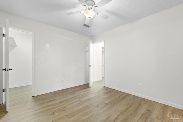 unfurnished room featuring ceiling fan, a textured ceiling, and light wood-type flooring