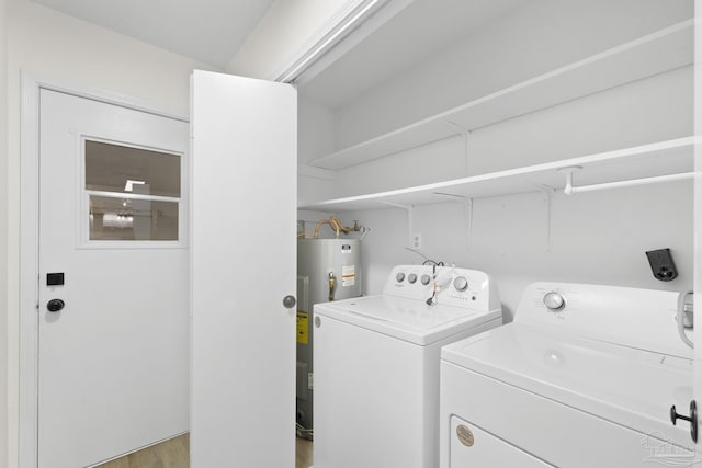 clothes washing area with separate washer and dryer and water heater