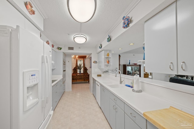 kitchen with a textured ceiling, white appliances, crown molding, sink, and a chandelier