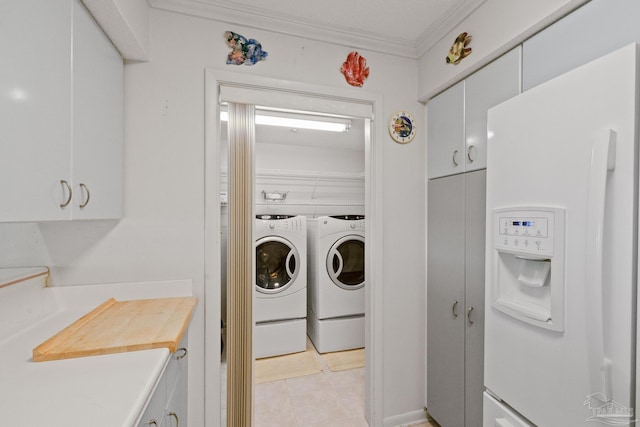 laundry area featuring separate washer and dryer, light tile patterned floors, and ornamental molding