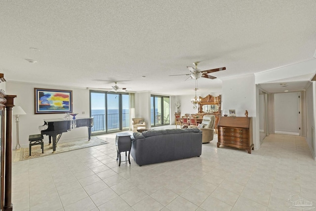 living room with ceiling fan, floor to ceiling windows, light tile patterned floors, and a textured ceiling