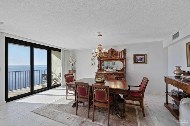 dining room with expansive windows, a water view, light tile patterned floors, a textured ceiling, and a notable chandelier