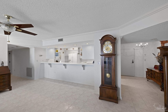 unfurnished living room featuring a textured ceiling, ceiling fan with notable chandelier, light tile patterned floors, and ornamental molding