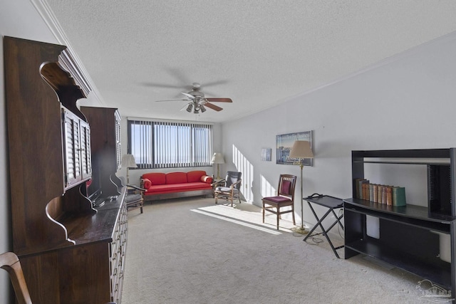 carpeted living room with crown molding, ceiling fan, and a textured ceiling