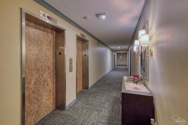 corridor with elevator and a textured ceiling