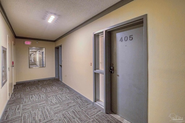 hallway featuring ornamental molding and a textured ceiling