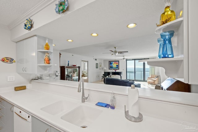 kitchen with dishwasher, sink, ceiling fan, a textured ceiling, and white cabinetry