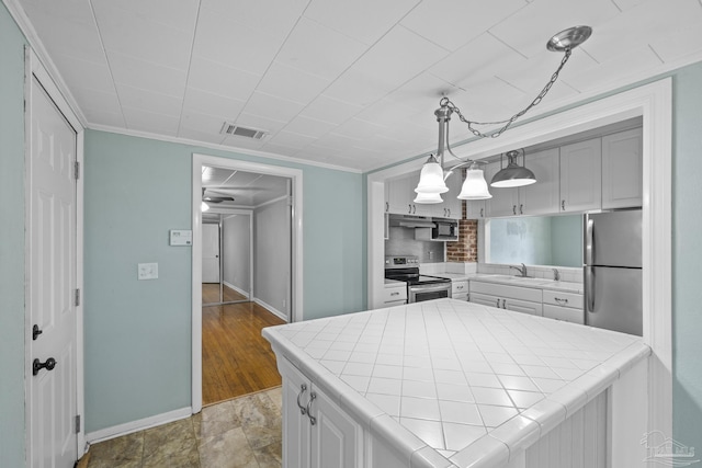 7074 Milton Ct, Milton, FL 32583 - kitchen featuring stainless steel appliances, tile countertops, baseboards, decorative backsplash, and a sink
