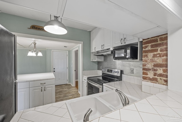 7074 Milton Ct, Milton, FL 32583 - kitchen with stainless steel electric stove, tile counters, black microwave, a sink, and under cabinet range hood