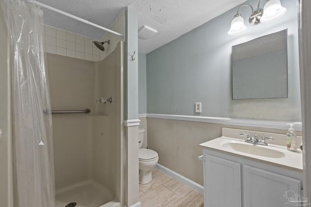7074 Milton Ct, Milton, FL 32583 - bathroom featuring toilet, vanity, a shower stall, baseboards, and a textured ceiling