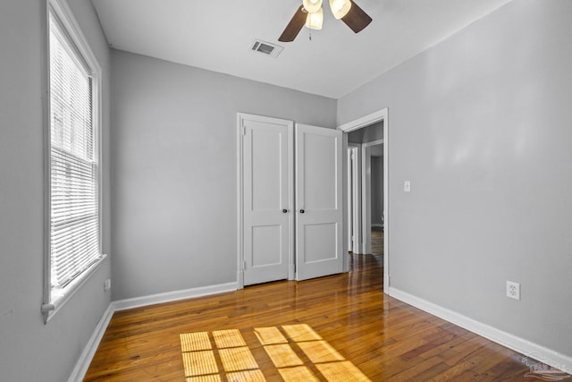 7074 Milton Ct, Milton, FL 32583 - unfurnished bedroom featuring baseboards, hardwood / wood-style flooring, and ceiling fan