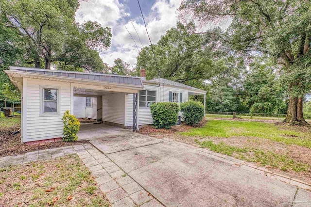 7074 Milton Ct, Milton, FL 32583 - view of front of property with an attached carport, concrete driveway, and a chimney