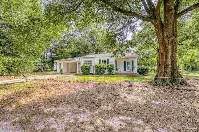 7074 Milton Ct, Milton, FL 32583 - manufactured / mobile home with a porch, driveway, an attached carport, and view of scattered trees