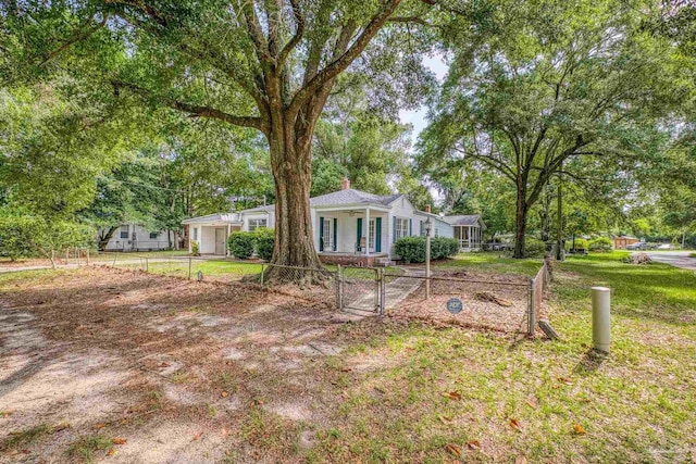 7074 Milton Ct, Milton, FL 32583 - ranch-style home featuring a chimney, a gate, and view of scattered trees