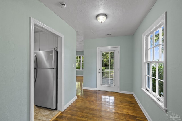 7074 Milton Ct, Milton, FL 32583 - doorway to outside with wood finished floors, plenty of natural light, a textured ceiling, and baseboards