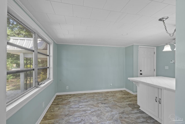 7074 Milton Ct, Milton, FL 32583 - unfurnished dining area featuring crown molding and baseboards