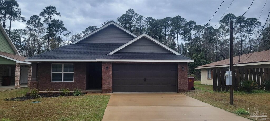 view of front facade with brick siding, a shingled roof, concrete driveway, an attached garage, and a front lawn