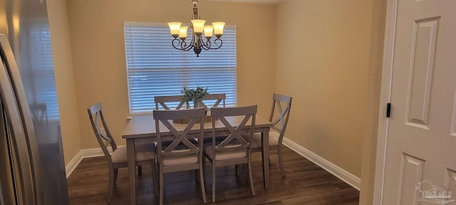 dining space with baseboards, dark wood finished floors, and an inviting chandelier