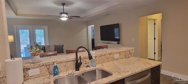 kitchen with a sink, open floor plan, stainless steel dishwasher, ornamental molding, and a raised ceiling