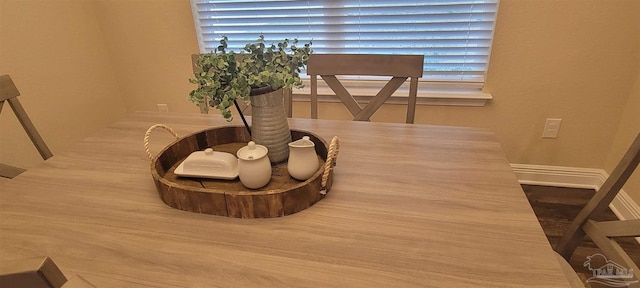 dining area with baseboards and wood finished floors