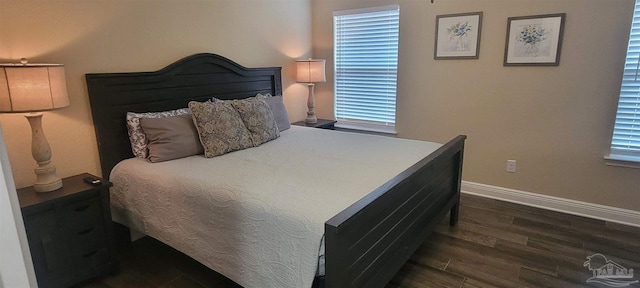 bedroom with dark wood finished floors and baseboards