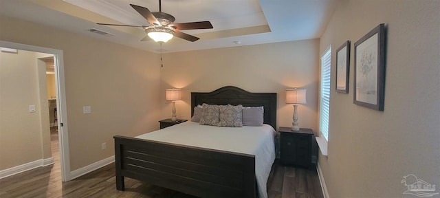 bedroom featuring baseboards, visible vents, dark wood finished floors, and a ceiling fan