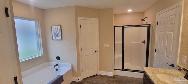 full bath featuring a garden tub, wood finished floors, vanity, baseboards, and a stall shower