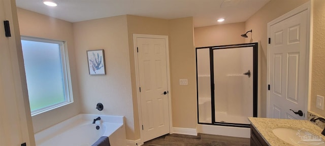 full bath featuring a garden tub, a closet, a stall shower, vanity, and baseboards