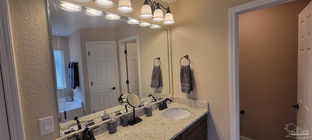 bathroom with a textured wall and vanity