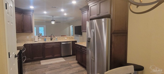 kitchen featuring visible vents, a breakfast bar area, appliances with stainless steel finishes, wood finished floors, and a sink