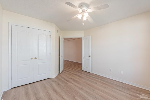 unfurnished bedroom featuring a textured ceiling, light hardwood / wood-style floors, ceiling fan, and a closet