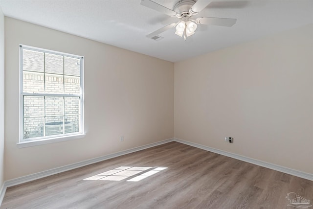 empty room with light wood-type flooring, ceiling fan, and a textured ceiling