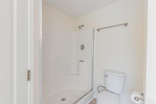 bathroom featuring walk in shower and toilet