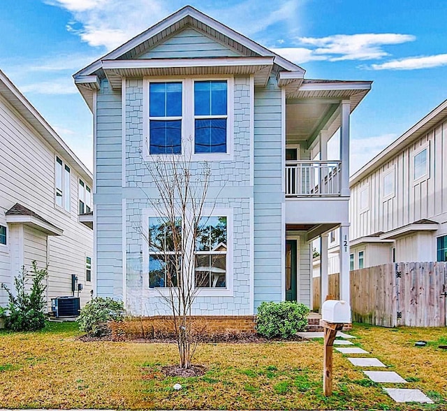 view of front of home featuring a front yard, central AC, and fence