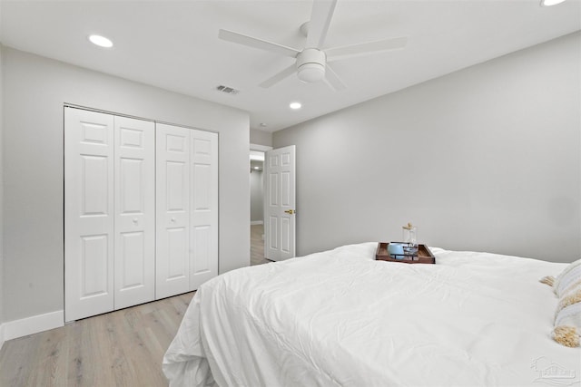 bedroom with light hardwood / wood-style floors, a closet, and ceiling fan