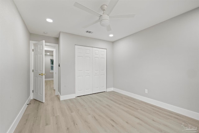 unfurnished bedroom with a closet, light wood-type flooring, and ceiling fan