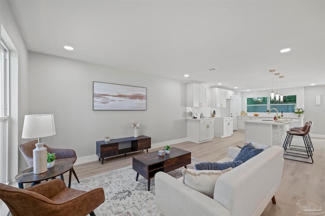 living room with light hardwood / wood-style floors and sink