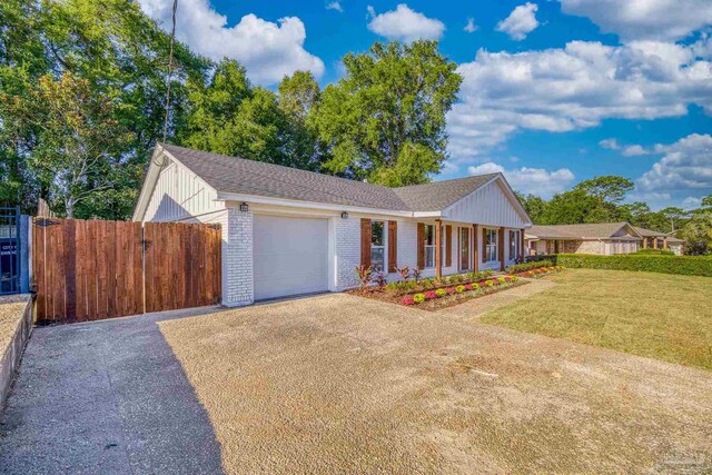 view of front facade with covered porch, a front yard, and a garage