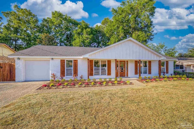 ranch-style house featuring a front lawn, covered porch, and a garage