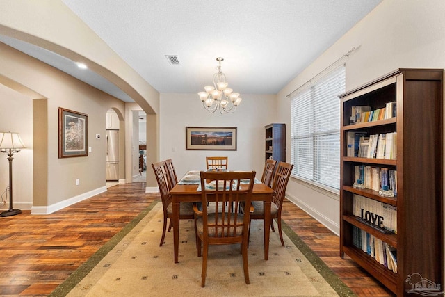 4951 Red Oak Dr, Milton, FL 32583 - dining area with visible vents, an inviting chandelier, wood finished floors, baseboards, and arched walkways