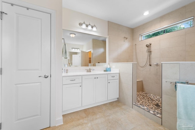 bathroom with tiled shower, vanity, and tile patterned floors